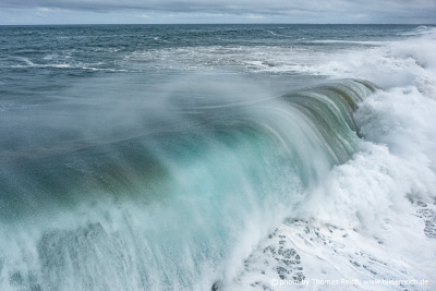 Meterhohe Wellen brechen an Küste